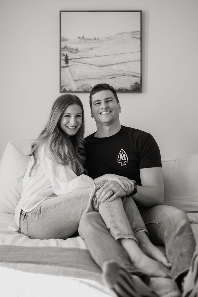 Black-and-white portrait of a couple sitting together at home.
