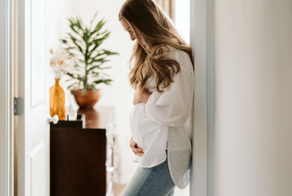Maternity portrait beside a bright window during the Genesis Midwifery session.