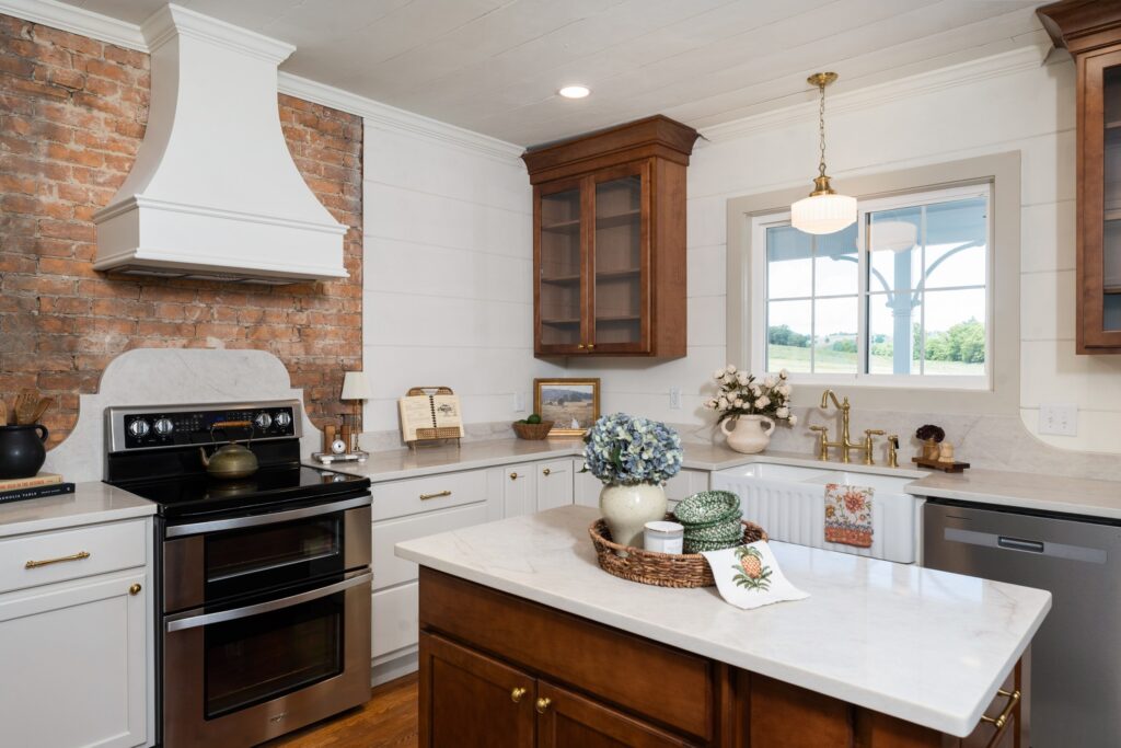 Kitchen with exposed brick, wood island and light cabinetry
