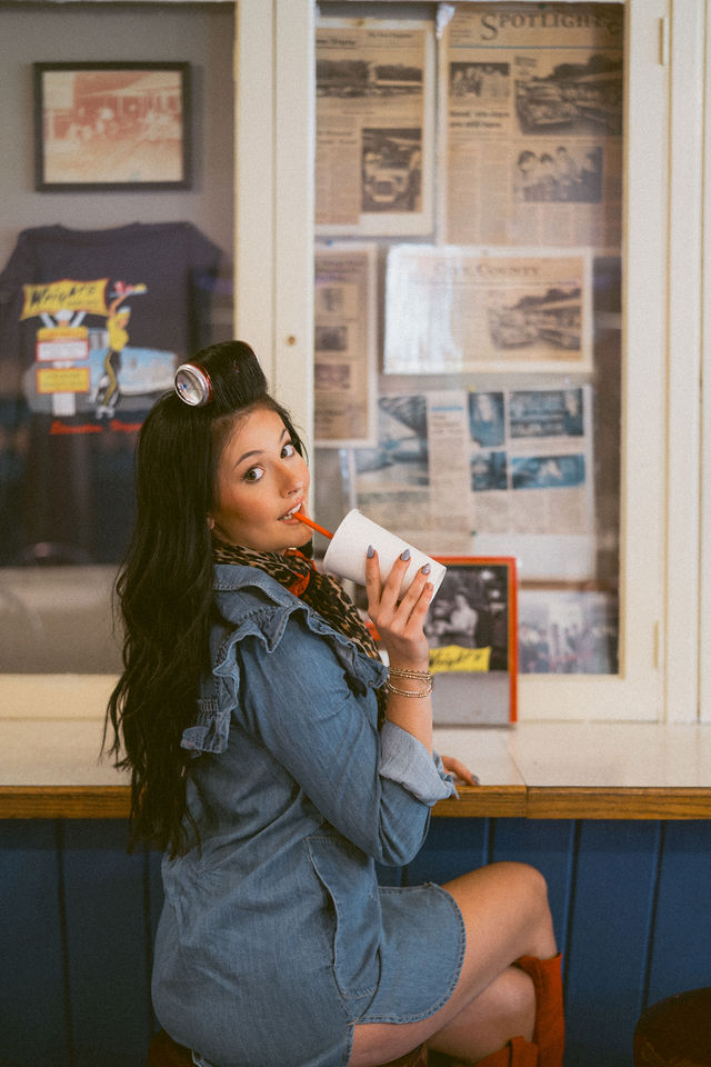 Hairstylist looking over her shoulder at a retro diner counter.