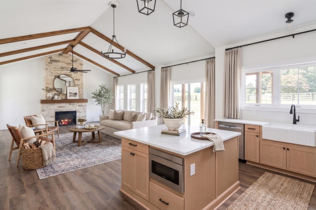 Open-plan kitchen and living room with exposed beams and stone fireplace